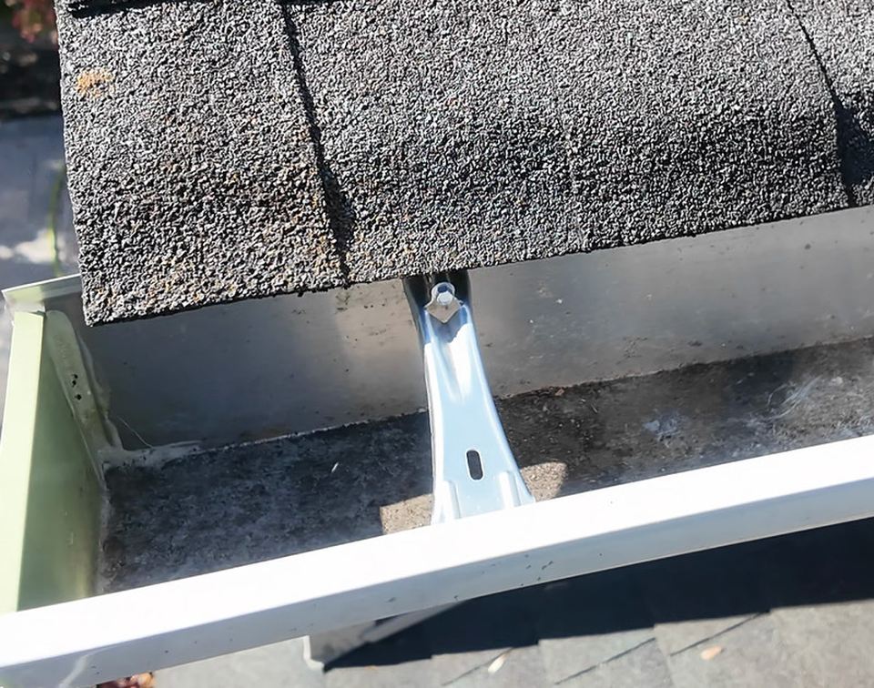 After cleaning: the same gutter trough with debris cleared.